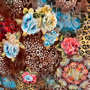 May include: A brown fabric with a floral pattern. The flowers are in shades of pink, blue, yellow, and white. The fabric also has a leopard print pattern.