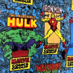 Peut inclure: Un tissu color&eacute; avec un motif r&eacute;p&eacute;t&eacute; de personnages de Marvel Comics, dont l'Incroyable Hulk, Iron Man et Wolverine. Le tissu pr&eacute;sente le logo de Marvel Comics Group en jaune, rouge et bleu.