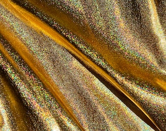 Könnte beinhalten: Nahaufnahme eines goldenen Stoffes mit schimmerndem, irisierendem Finish. Der Stoff ist zerknittert und hat eine subtile Textur.