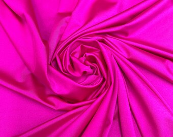 May include: A close-up of a vibrant pink fabric, draped and folded to create a soft, swirling pattern. The fabric has a smooth, silky texture.