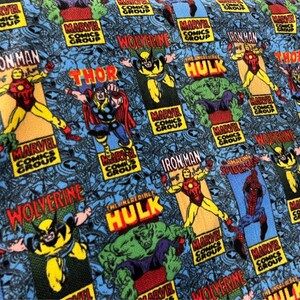 Peut inclure: Un tissu bleu avec un motif r&eacute;p&eacute;t&eacute; de personnages de Marvel Comics, notamment Iron Man, Thor, Wolverine, Hulk et Spider-Man. Le tissu pr&eacute;sente le logo de Marvel Comics Group et les noms des personnages en lettres blanches et grasses.
