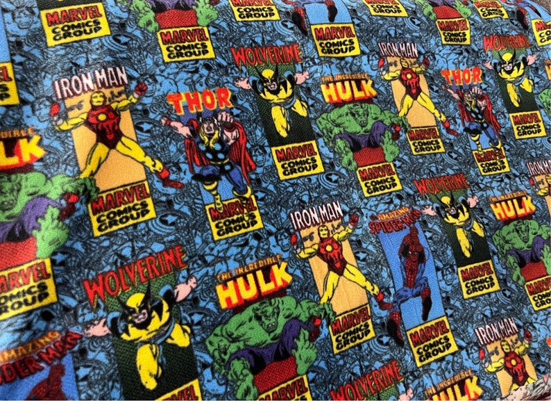 Peut inclure: Un tissu bleu avec un motif r&eacute;p&eacute;t&eacute; de personnages de Marvel Comics, notamment Iron Man, Thor, Wolverine, Hulk et Spider-Man. Le tissu pr&eacute;sente le logo de Marvel Comics Group et les noms des personnages en lettres blanches et grasses.