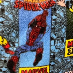 Peut inclure: Un personnage de bande dessin&eacute;e bleu et rouge, Spider-Man, est repr&eacute;sent&eacute; en train de sauter. L'arri&egrave;re-plan est un motif de bande dessin&eacute;e bleu et noir avec le texte "AMAZING SPIDER-MAN" et "MARVEL COMICS GROUP".
