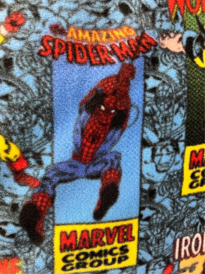Peut inclure: Un personnage de bande dessin&eacute;e bleu et rouge, Spider-Man, est repr&eacute;sent&eacute; en train de sauter. L'arri&egrave;re-plan est un motif de bande dessin&eacute;e bleu et noir avec le texte "AMAZING SPIDER-MAN" et "MARVEL COMICS GROUP".