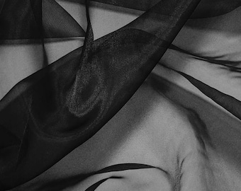 May include: Close-up of black sheer fabric with a flowing, draped appearance. The fabric has a glossy sheen, with folds and shadows creating depth and texture. The material appears lightweight and delicate, suitable for apparel or decorative purposes.