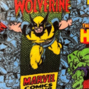 Peut inclure: Un tissu bleu et jaune avec un motif de bande dessin&eacute;e mettant en sc&egrave;ne Wolverine, Hulk et le logo de Marvel Comics Group. Le tissu a une texture duveteuse.
