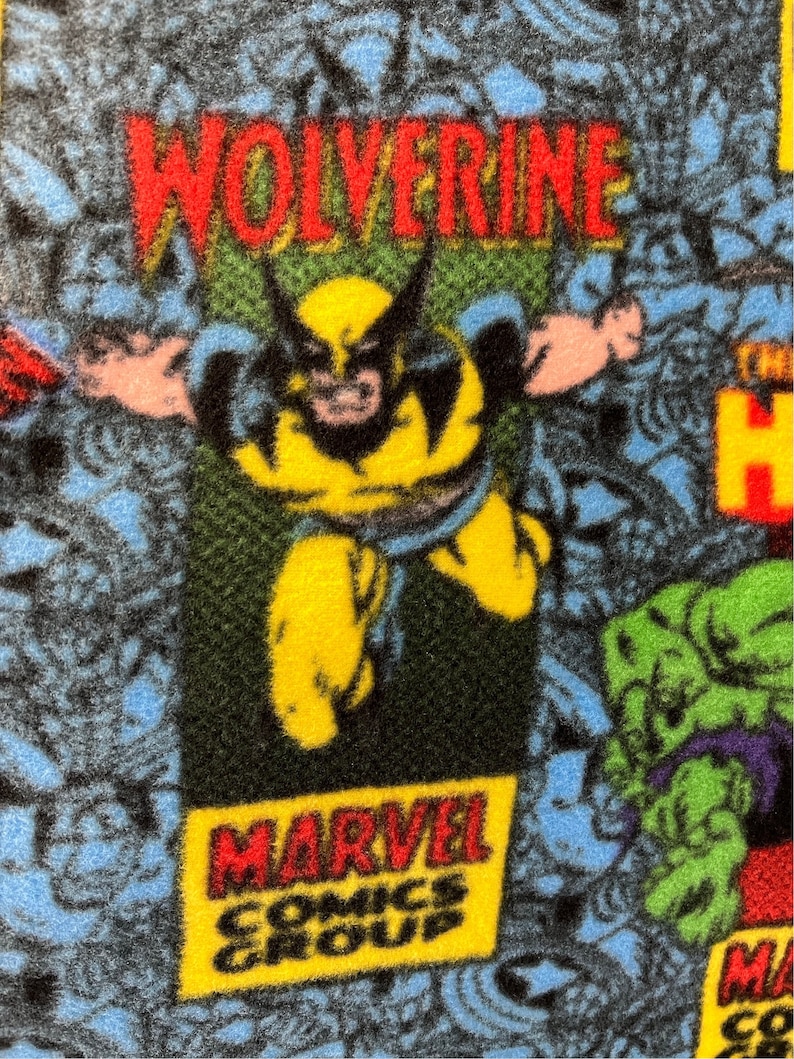 Peut inclure: Un tissu bleu et jaune avec un motif de bande dessin&eacute;e mettant en sc&egrave;ne Wolverine, Hulk et le logo de Marvel Comics Group. Le tissu a une texture duveteuse.