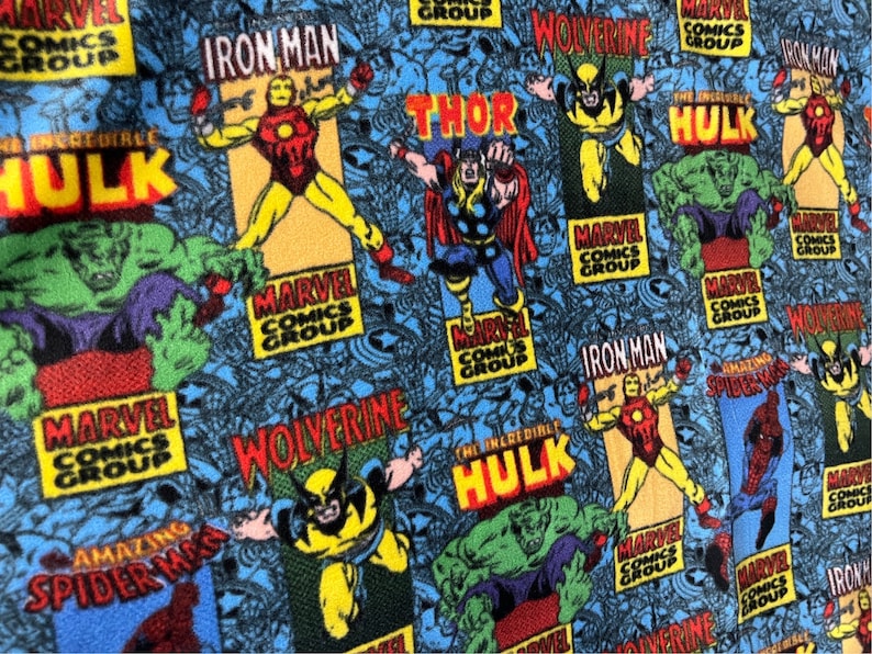 Peut inclure: Un tissu bleu avec un motif r&eacute;p&eacute;t&eacute; de personnages de Marvel Comics, dont Iron Man, Thor, Wolverine et The Incredible Hulk. Le tissu pr&eacute;sente le logo de Marvel Comics Group et les noms des personnages dans une typographie de style bande dessin&eacute;e.