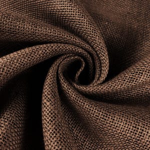 May include: Close-up of a brown burlap fabric with a woven texture. The fabric is folded and draped, creating shadows and depth. The natural material has a rustic appearance.