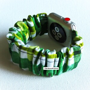 Peut inclure: Un bracelet de montre Apple &agrave; carreaux verts et blancs avec une Apple Watch argent&eacute;e. Le bracelet est en tissu et a une sensation &eacute;lastique et extensible. Le texte "Checkered Green" est imprim&eacute; sur le bracelet.