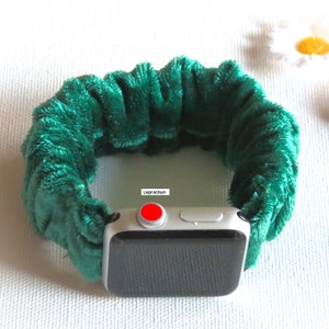 Peut inclure: Un bracelet de montre en velours vert pour une Apple Watch. Le bracelet est en tissu doux et pelucheux et porte l'&eacute;tiquette "Leprachun" sur le c&ocirc;t&eacute;.