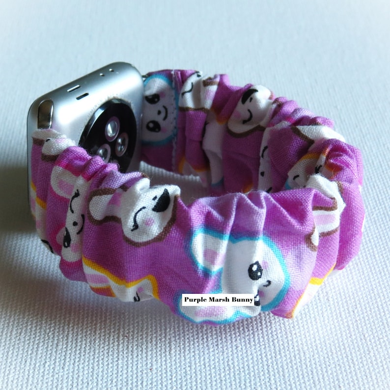 May include: A purple Apple Watch band with a white bunny pattern. The band is made of a soft, stretchy fabric and has a comfortable fit. The band is designed to fit Apple Watch Series 4 and later.