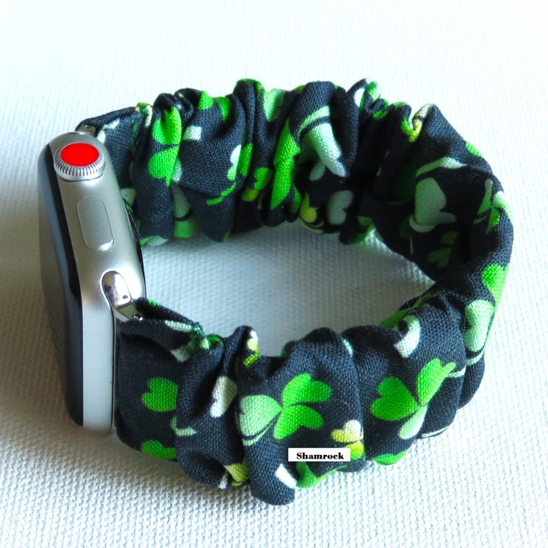 Peut inclure: Un bracelet de montre noir et vert avec un imprim&eacute; tr&egrave;fle. Le bracelet est en tissu et est r&eacute;glable. Le bracelet est compatible avec Apple Watch.