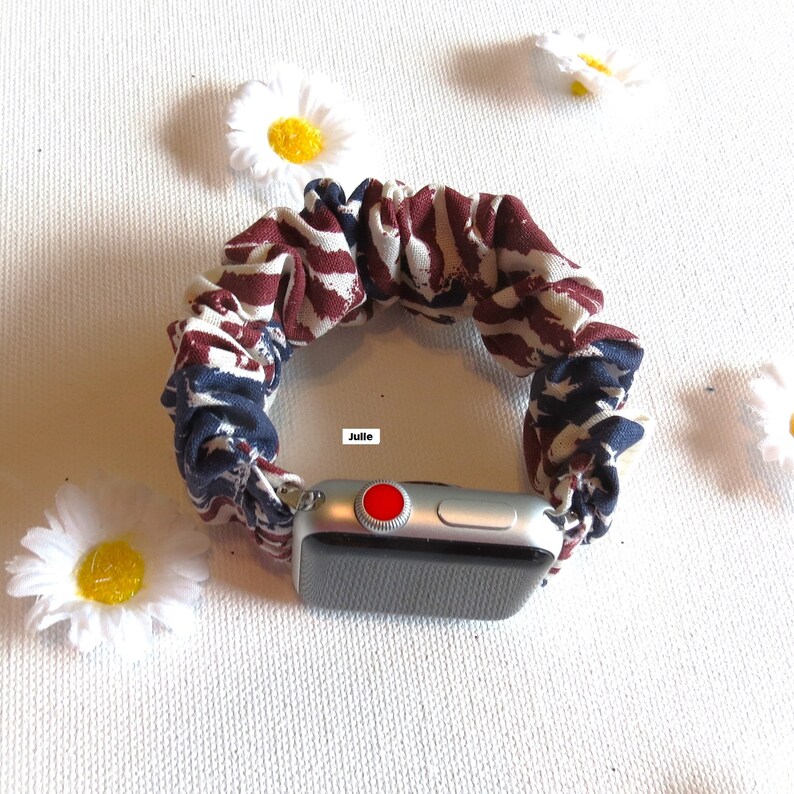 Op de afbeelding: Een Apple Watch-band van stof met een rood, wit en blauw patroon. De band is gemaakt van zacht, rekbaar materiaal en is ontworpen om te passen op de meeste Apple Watch-maten.