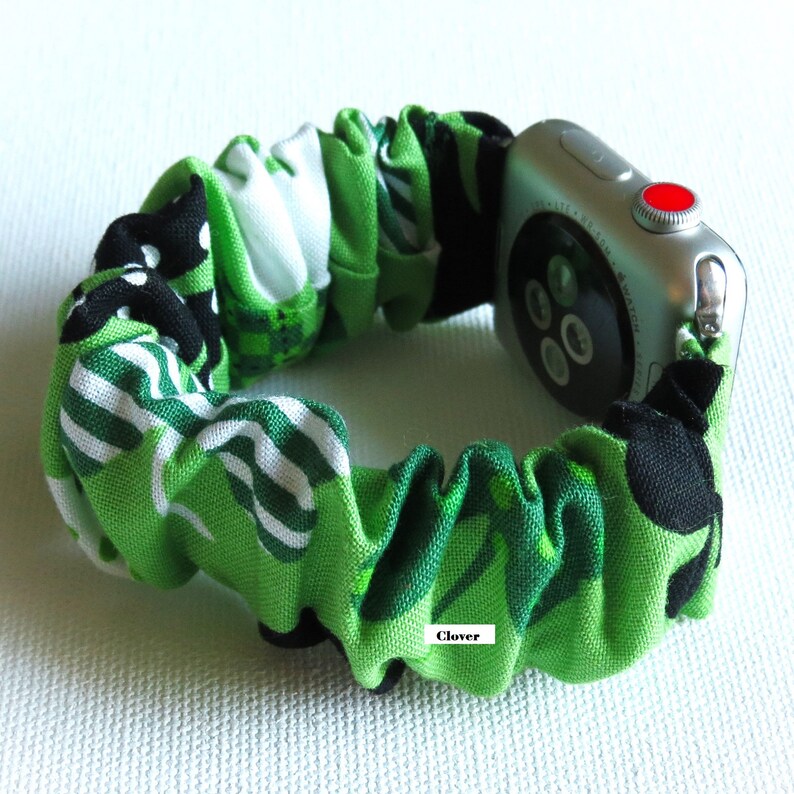 Peut inclure: Un bracelet de montre Apple en tissu &agrave; motif vert, noir et blanc avec le mot "Clover" imprim&eacute; dessus.