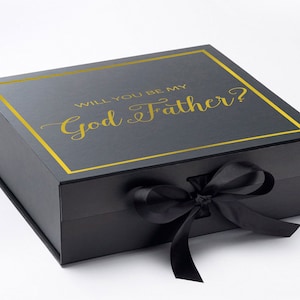 May include: Black gift box with a gold ribbon and the text "Will you be my God Father?" in gold lettering.