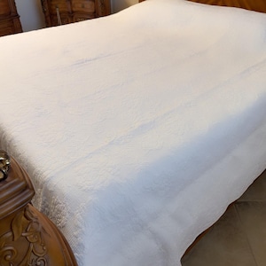 以下が含まれることがあります： 上品なエンボス加工が施された白いキルトのベッドスプレッド。ベッドスプレッドは柔らかく高級感のある生地で作られており、どんな寝室にもエレガントな雰囲気を添えるのに最適です。