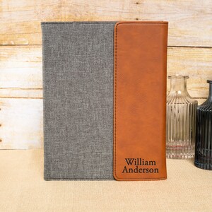 May include: A gray and brown leatherette journal with the name "William Anderson" embossed on the front.