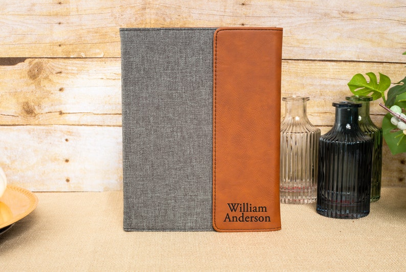 May include: A gray and brown leatherette journal with the name "William Anderson" embossed on the front.