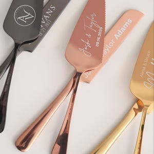 May include: Three personalized cake serving sets with gold, rose gold, and black handles. The sets are engraved with names and dates. The gold set has the text "Alexa & Bruce", the rose gold set has the text "Josh & Taylor 09.16.2025", and the black set has the text "N Vans 10.23.2023".