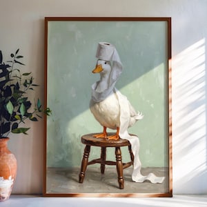 May include: A framed painting of a white duck with an orange beak standing on a small wooden stool. The duck is draped in white toilet paper, with a roll of toilet paper balanced on its head. The background is a solid, light mint green color.