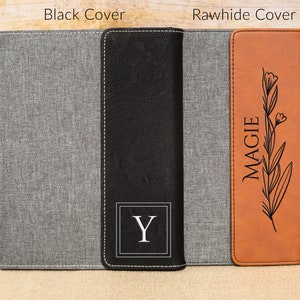 May include: Two personalized notebook covers, one with a black cover and the initial "Y" and the other with a brown leather cover with the name "MAGGIE" and a floral design.