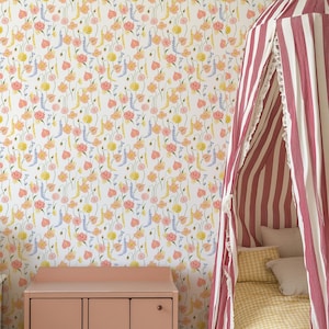 May include: A bedroom scene featuring floral wallpaper with pink, yellow, and blue flowers on a white background. A pink dresser is in the foreground, and a striped canopy bed with pillows and a yellow gingham blanket is on the right.