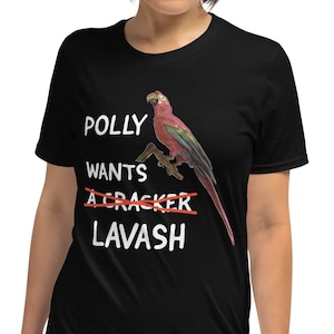 May include: Black t-shirt with a white graphic of a parrot and the text "Polly wants a cracker" with "cracker" crossed out and "lavash" written below.