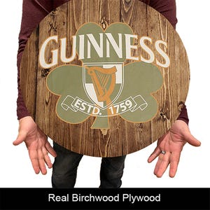 May include: A round wooden sign with a green shamrock and the words "GUINNESS ESTD. 1759" in white lettering.