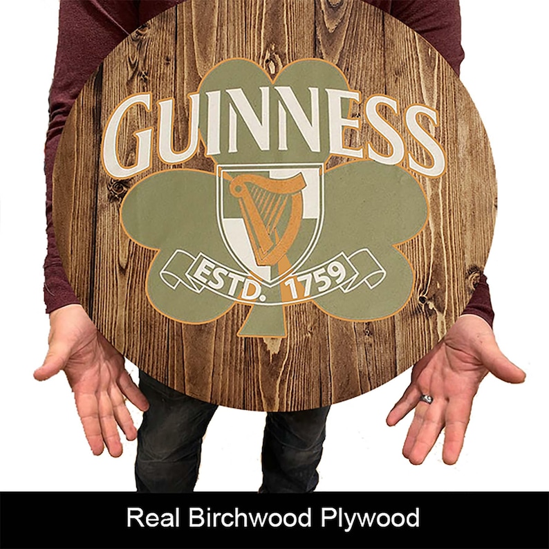 May include: A round wooden sign with a green shamrock and the words "GUINNESS ESTD. 1759" in white lettering.