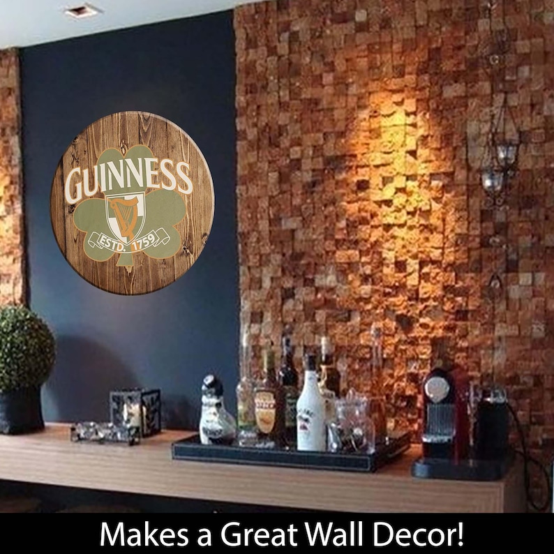 May include: A wooden round sign with a green shamrock and the words "GUINNESS ESTD. 1759" in a brown brick wall setting. Makes a Great Wall Decor!