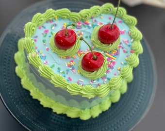 Faux gâteau coeur, bordure en coquillages verts et cerises