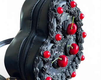 Monedero con forma de corazón negro y perla roja helada y cerezas