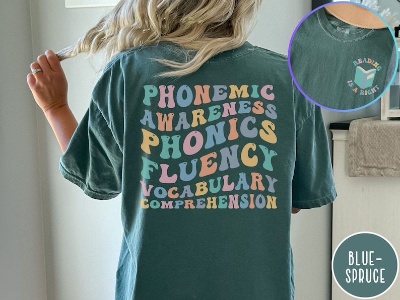 May include: A teal blue t-shirt with the words "phonemic awareness, phonics, fluency, vocabulary, comprehension" printed in rainbow colors on the back. The shirt also has a small graphic of a book with the text "Reading is a right" on the right side of the back.