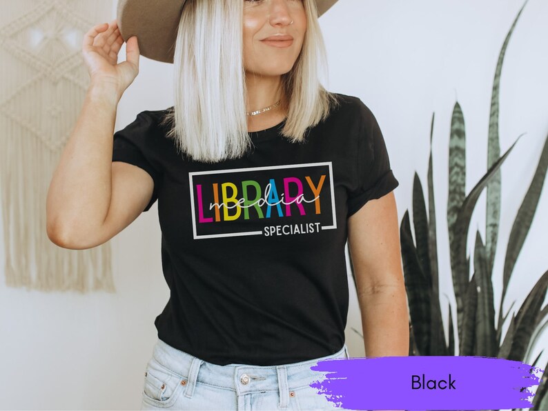 May include: Black t-shirt with the text "LIBRARY MEDIA SPECIALIST" in a rainbow color scheme.