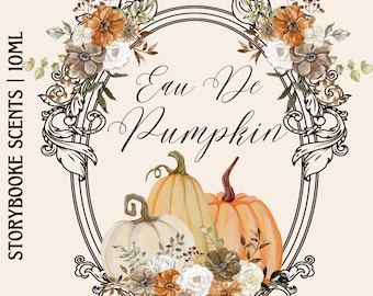 May include: A black and white ornate frame with a floral design surrounding three pumpkins. The pumpkins are white, orange, and a light brown color. The text "Eau De Pumpkin" is written in black cursive inside the frame.