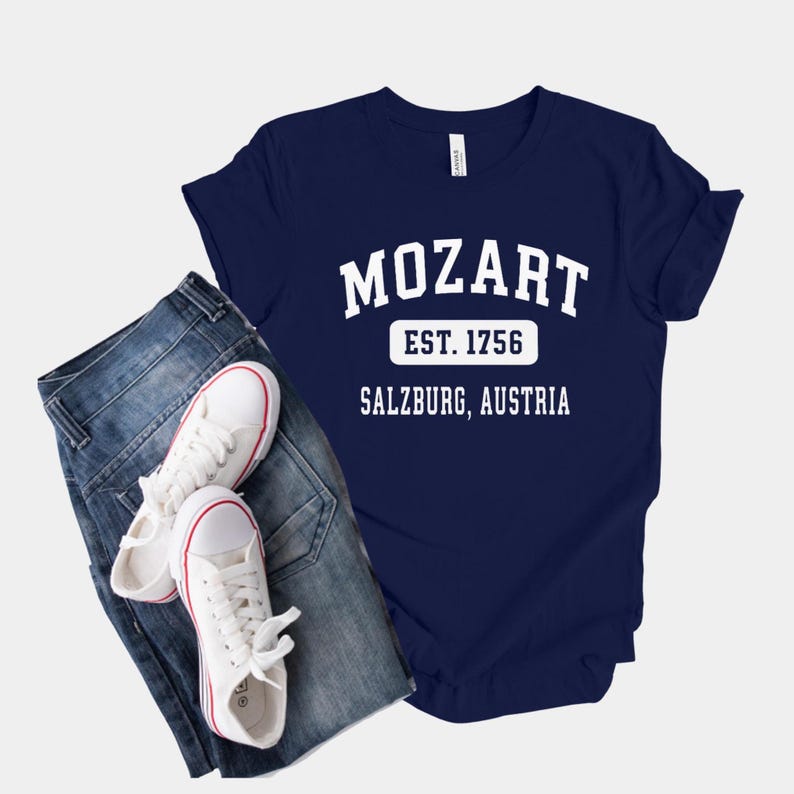 May include: A navy blue t-shirt with white text that reads "Mozart Est. 1756 Salzburg, Austria".
