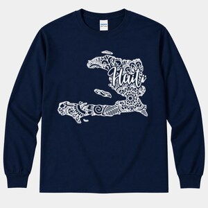 Puede incluir: Una camiseta de manga larga azul marino con un gráfico blanco del mapa de Haití. El mapa está relleno de intrincados patrones de estilo mandala e incluye la palabra Haití escrita en una letra cursiva blanca en el centro.