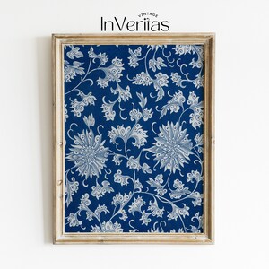 May include: A framed print featuring a blue background with a white floral design. The print is in a light wood frame.