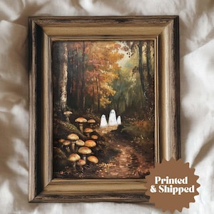 May include: A framed print depicting a forest scene with mushrooms and three white ghosts. The artwork has a vintage aesthetic with warm autumn colours and a detailed, textured appearance. The frame is a warm, antique gold colour. The text "Printed & Shipped" is on the bottom right.