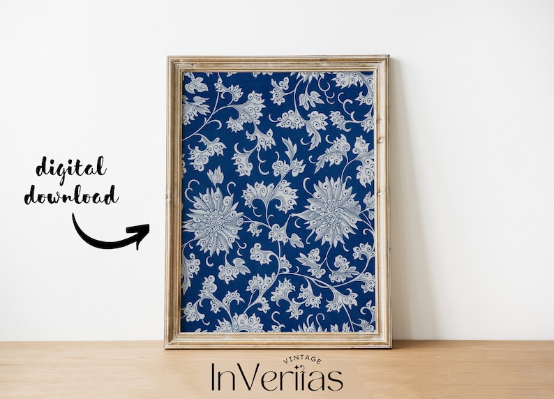 May include: A framed print of a vintage blue and white floral pattern. The pattern features stylised flowers and leaves. The frame is a light wood colour.
