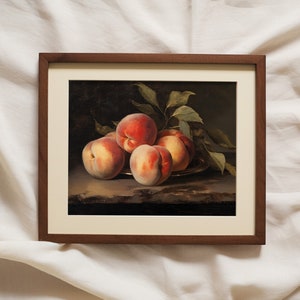 May include: A framed still life painting of a group of peaches on a plate with green leaves. The peaches are a mix of red and yellow, and the leaves are a deep green.