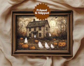 May include: A framed painting depicting a spooky house with a porch light, surrounded by pumpkins and ghosts. The house is painted in shades of brown and grey, with white trim. The pumpkins are orange and the ghosts are white.