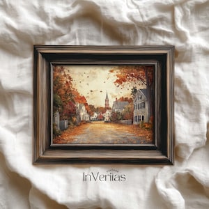 May include: A framed landscape painting depicting a quaint town scene in autumn. The artwork features a road lined with houses and trees with vibrant fall foliage. The frame is dark brown, and the painting has a vintage aesthetic. The text "Vintage InVeriias" is at the bottom.