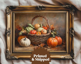 May include: A framed oil painting of a still life featuring a basket overflowing with gourds, pumpkins, and other fall harvest vegetables. The basket is woven and brown, and the gourds and pumpkins are various shades of orange, yellow, and green. The painting is set against a brown background.