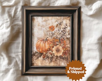Pode incluir: Obra de arte emoldurada com uma pintura em aquarela de uma abóbora e flores de outono em tons de laranja, marrom e bege. A obra de arte está em uma moldura de madeira marrom escura. A imagem inclui o texto "Printed & Shipped".