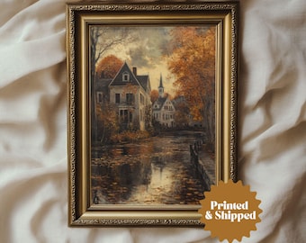 Pode incluir: Uma pintura a óleo emoldurada que retrata uma pitoresca cena de vila com uma casa, árvores e um rio. A pintura está emoldurada em uma moldura dourada com detalhes ornamentados.