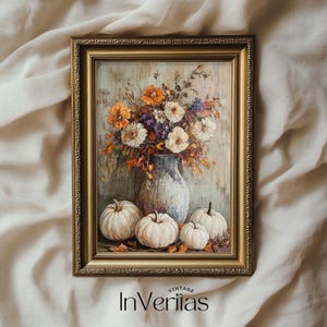 Pode incluir: Uma pintura vintage emoldurada que retrata um buquê de flores brancas e laranja em um vaso azul com três abóboras brancas na frente do vaso. A pintura está sobre um fundo verde e marrom.
