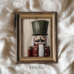 May include: A framed vintage wooden nutcracker figurine. The nutcracker has a green top hat, a black mustache, and a red jacket. The frame is a light brown colour, and the background is a light beige colour. The text "VINTAGE InVeriitas" is at the bottom.