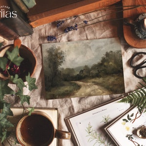 May include: A vintage painting of a winding dirt road through a forest, framed and displayed on a table with books, plants, and a candle. The painting has a rustic, earthy feel.